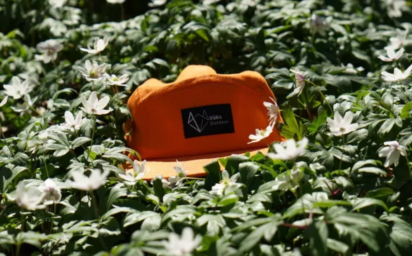 Vöks Outdoor five-panel orange keps i i ett hav av vitsippor